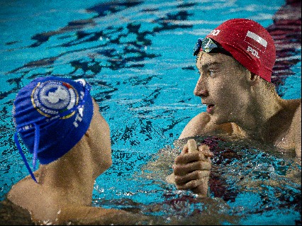 Two swimmers handshake in the pool after competed